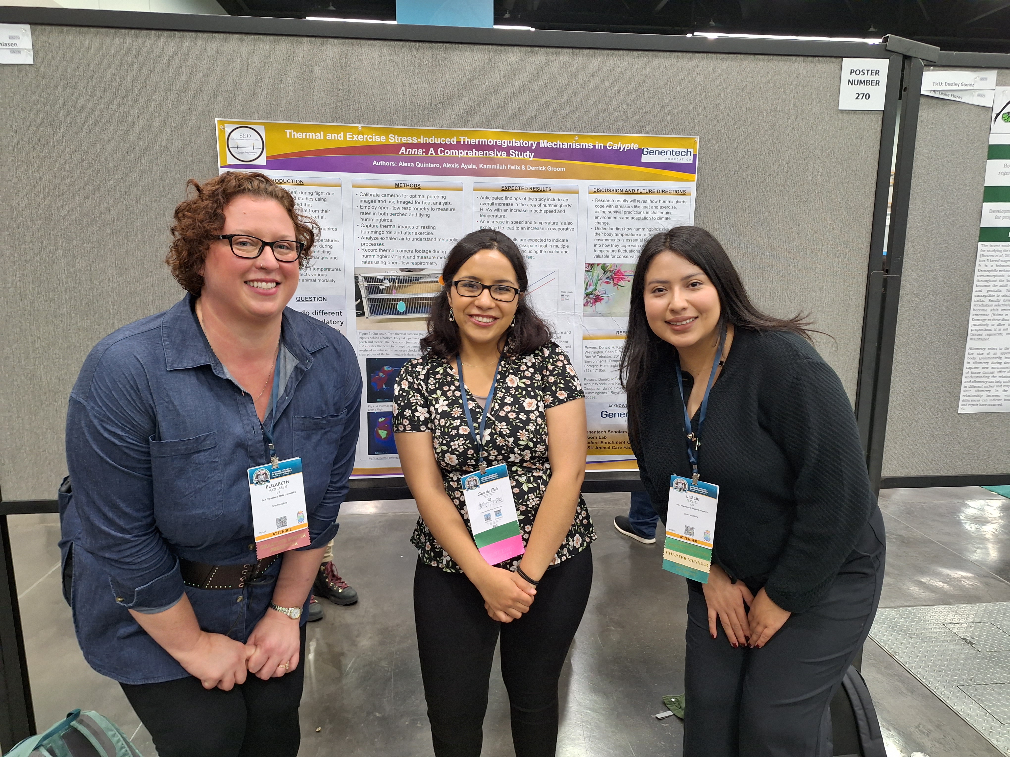 Group of three students in front of research poster.